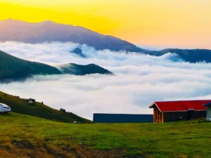 نمایی از روستای اسپرز سوادکوه در ارتفاعات البرز، پوشیده از ابرها و چمنزارهای سبز در فصل بهار