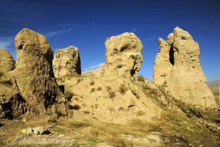 نمایی از تپه باستانی گیان در نهاوند، با حصار فلزی جدید برای حفاظت از آثار تاریخی و جلوگیری از ورود غیرمجاز، در پس‌زمینه چشم‌انداز طبیعی همدان دیده می‌شود.